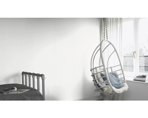 Lichte kamer met bed en hangende rotan stoel bij het raam