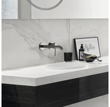 Moderne badkamer met wastafel, kraan, zeepdispenser en decoratieve elementen.