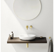 Moderne badkamer met ronde spiegel, opzetwastafel, houten console en gouden kranen.