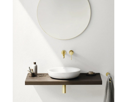 Moderne badkamer met ronde spiegel, opzetwastafel, houten console en gouden kranen.