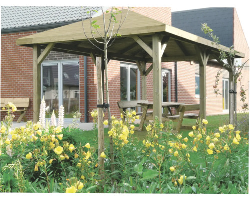 Houten paviljoen met tafel en banken in een tuin met bloemen.