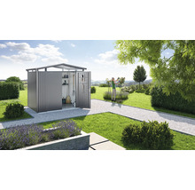 Tuinscene met een open gereedschapsschuur met planken en ophangsystemen en een vrouw die tuiniert