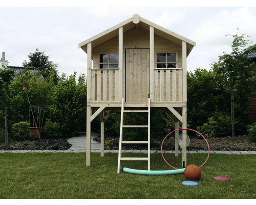 Houten speelhuis met ladder in de tuin