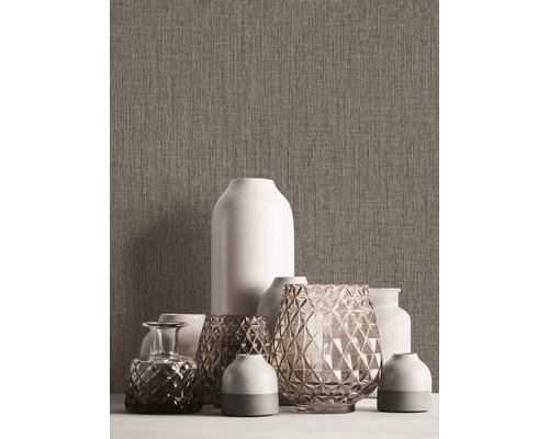 Diverse decoratieve vazen op een tafel voor een gestructureerde muur.