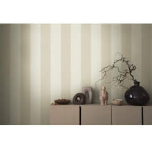 Decoratieve schikking op een kast voor een gestreept behang.