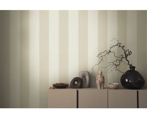 Decoratieve schikking op een kast voor een gestreept behang.