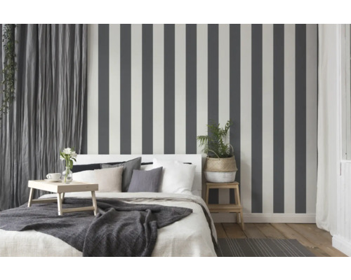 Slaapkamer met bed, nachtkastje en gestreept behang