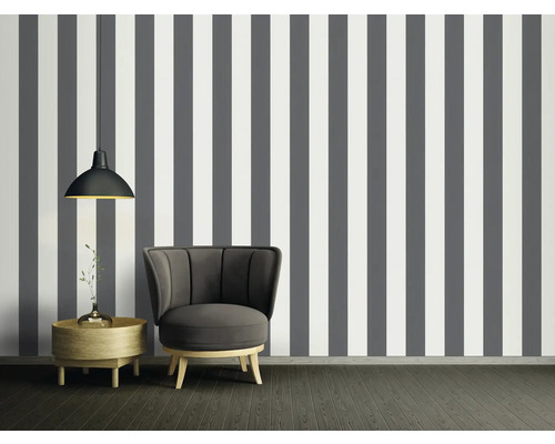 Kamerweergave met gestreept behang in grijs en wit, fauteuil, bijzettafel en hanglamp