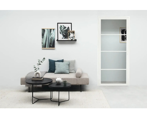 Lichte woonkamer met bank, salontafels, decoratie en deur