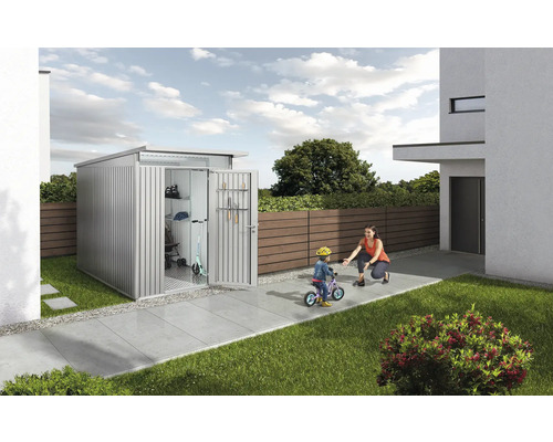 Metalen gereedschapsschuur met open deur, kind op fiets en vrouw in de tuin