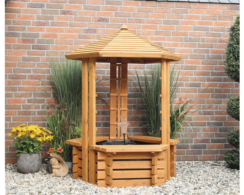 Houten waterput met dak en fontein in de tuin