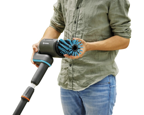 Man houdt een GARDENA borstel met wateraansluiting in zijn hand