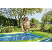 Man gebruikt een dompelpomp om water uit een zwembad in de tuin te pompen.