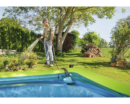 Scene van een man die een zwembad vult met een tuinslang.