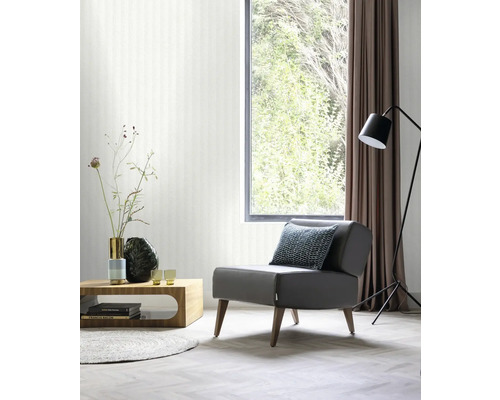 Woonkamer met fauteuil, tafel, staande lamp en raam