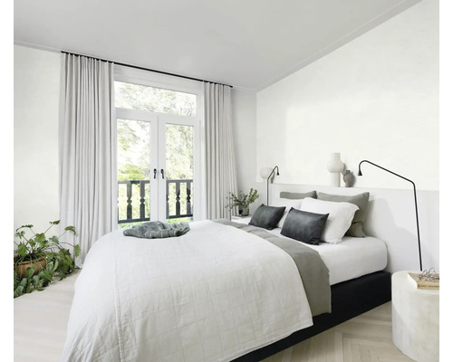 Lichte slaapkamer met bed, nachtkastje, lamp, gordijnen en kamerplant