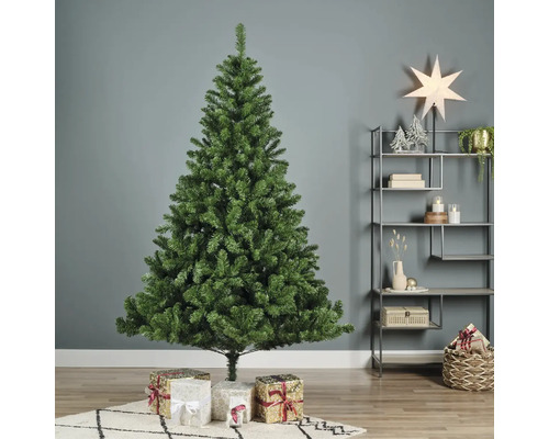Kunstmatige groene kerstboom met geschenken in de woonkamer.