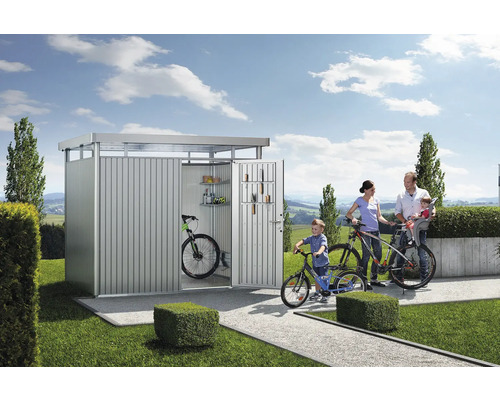 Gezin met fietsen voor metalen fietsengarage in de tuin