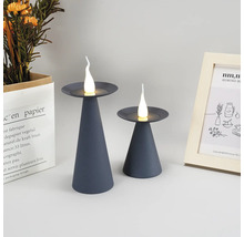 Twee grijze LED-kaarslampen op een tafel, decoratieve elementen op de achtergrond