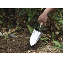 Tuinman plant met een plantschop in de tuin.