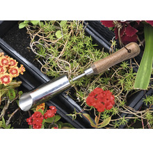 Plantgatboor van metaal met houten handvat tussen planten