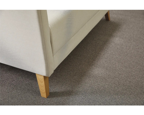 Detail van een witte bank met houten poten op een grijs tapijt