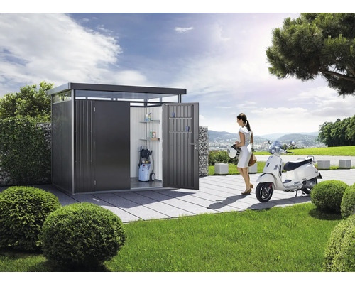 Moderne metalen gereedschapskast met planken, hogedrukreiniger en een vrouw met scooter in de tuin.