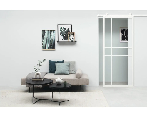 Woonkamer met bank, salontafels, wanddecoratie en schuifdeur