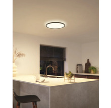 Een moderne keuken met een ronde plafondlamp die zorgt voor een heldere en uitnodigende sfeer.