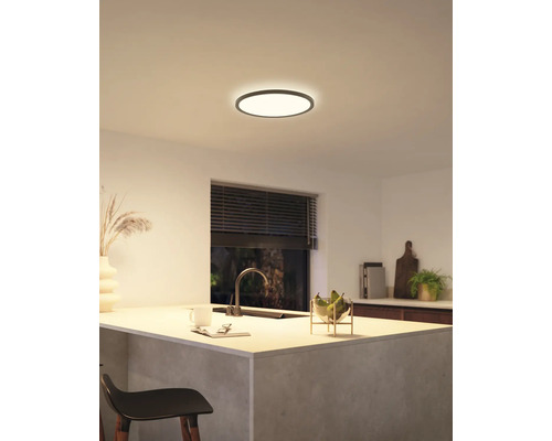 Een moderne keuken met een ronde plafondlamp die zorgt voor een heldere en uitnodigende sfeer.