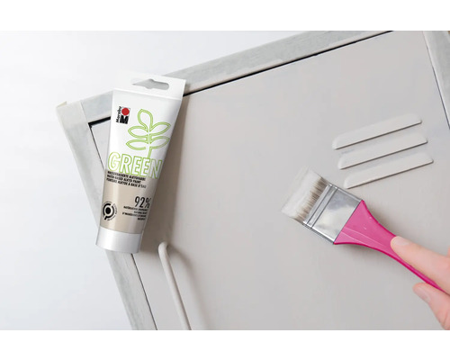 Pot groene alkydverf en kwast bij het schilderen van een metalen kast