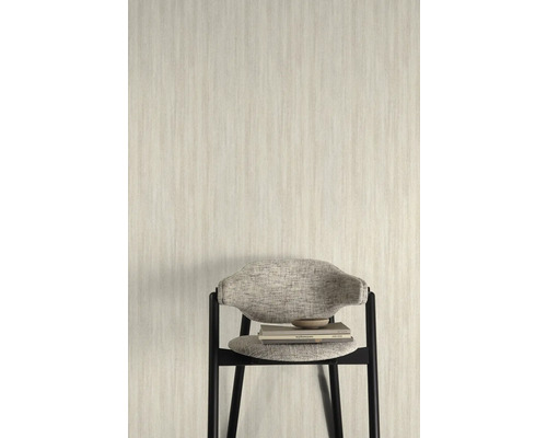 Licht behang met fijne structuur op de achtergrond, met een stoel met boeken ervoor