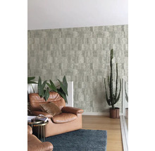 Woonkamer met patroonbehang, lederen fauteuil en cactus