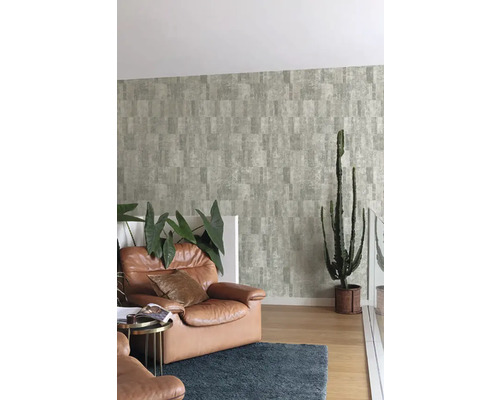 Woonkamer met patroonbehang, lederen fauteuil en cactus