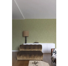 Woonkamer met bank, lamp en decoratie op een dressoir voor een muur met patroon
