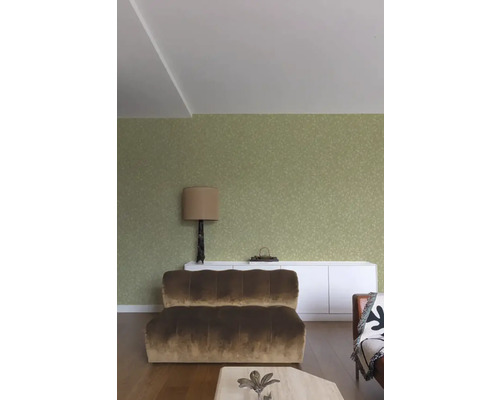 Woonkamer met bank, lamp en decoratie op een dressoir voor een muur met patroon