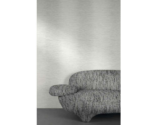 Close-up van een grijs structuurbehang boven een bank.