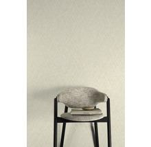 Close-up van een muur met een gestructureerd behang en een stoel met boeken