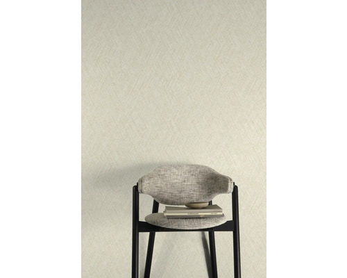 Close-up van een muur met een gestructureerd behang en een stoel met boeken