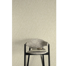 Behang met visgraatmotief achter een stoel met boeken