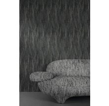 Grijze structuurbehang met bijpassende sofa op de achtergrond