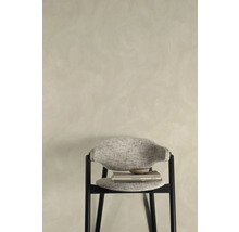 Decoratief interieur met stoel, boeken en schaal tegen een muur