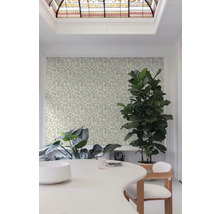 Lichte kamer met behang met bloemmotief, tafel en kamerplanten.