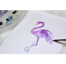 Aquarelschilderij van een flamingo op papier met penseel en verfpalet