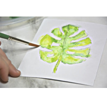 Aquarelschilderij van een Monstera blad met penseel op papier