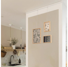 Drie ingelijste foto''s hangen aan een wandrail in een kamer.