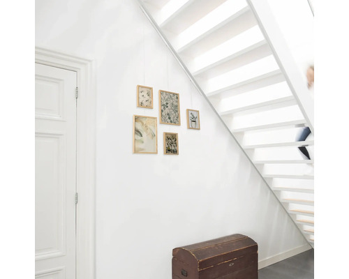 Hal met witte trap, houten kist en hangende ingelijste foto''s met botanische prints