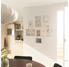 Woonkamer met fotogalerij aan de muur en eettafel