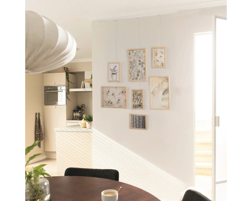 Woonkamer met fotogalerij aan de muur en eettafel