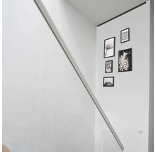Scene van een trappenhuis met fotolijsten en foto''s aan een wand.